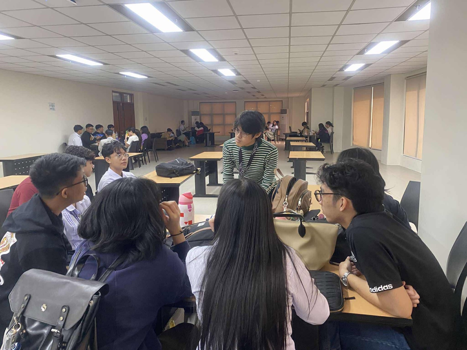 Students gathering around a table in a campus hall